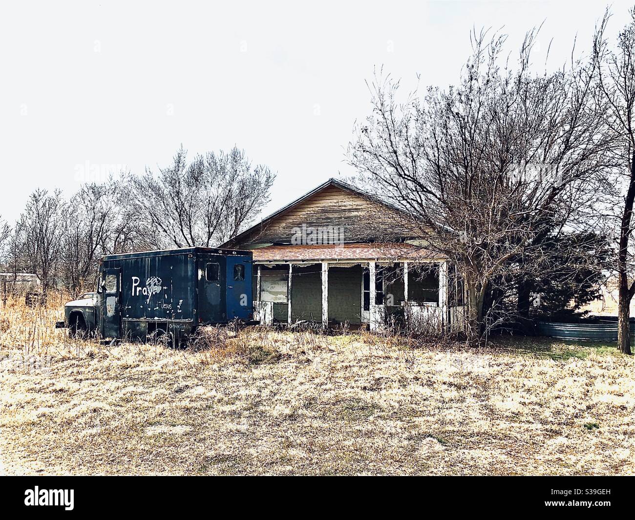 Casa abandonada con camión de oración Foto de stock