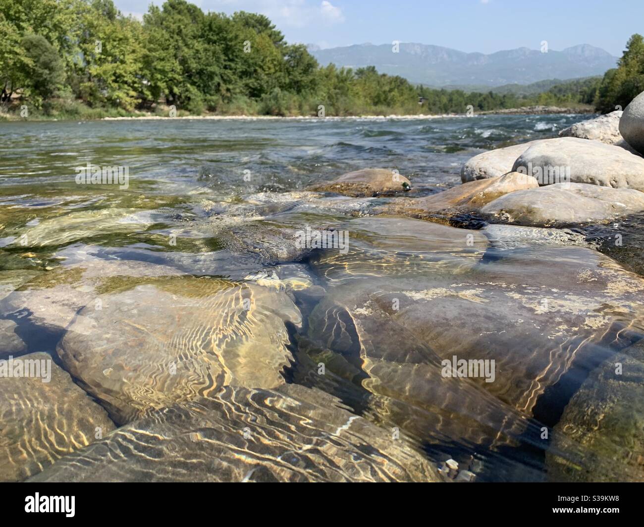 Ondulaciones de agua que fluye sobre rocas en el río Manavgat en turquía Foto de stock