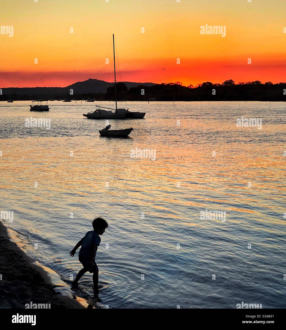 Niño Silhouette en la playa Noosa River Queensland Australia Foto de stock