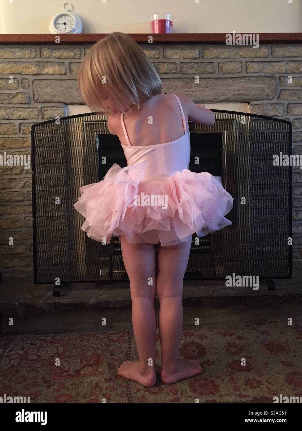 Una niña en un tutu rosa con botas rosa paseos a lo largo de Fotografía de  stock - Alamy