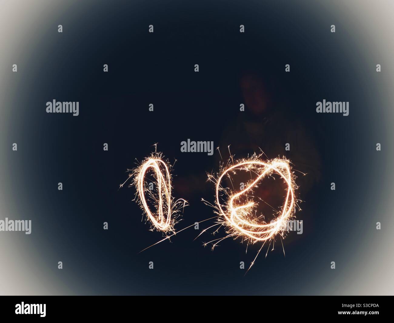Dos Sparklers dando un patrón de círculos por la noche Foto de stock