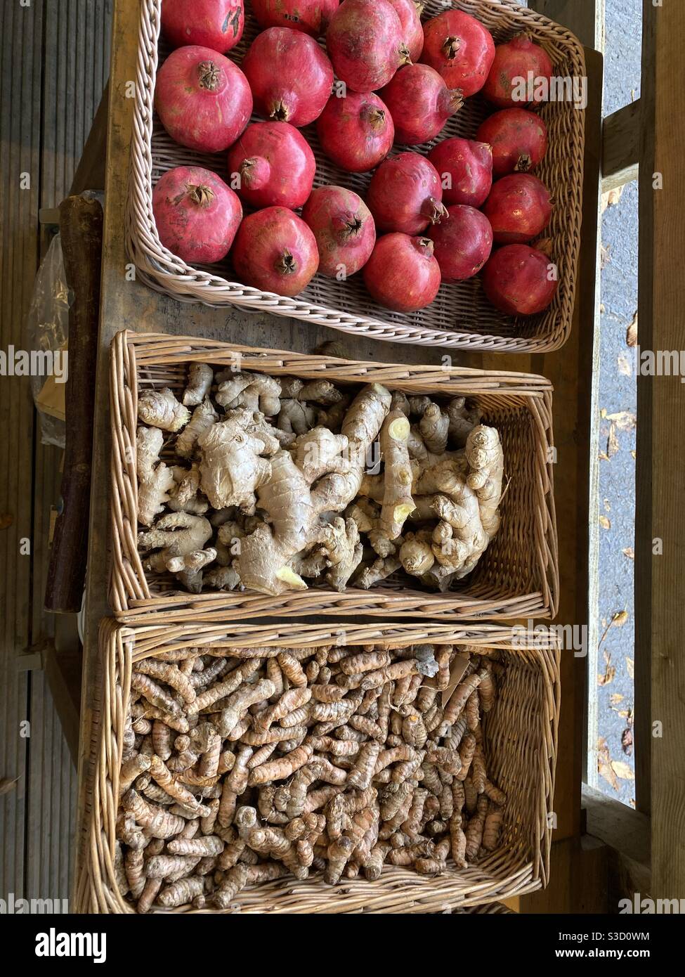 Pomegranados orgánicos, raíz de ajo y Turmeric fresco en cestas para la venta Foto de stock