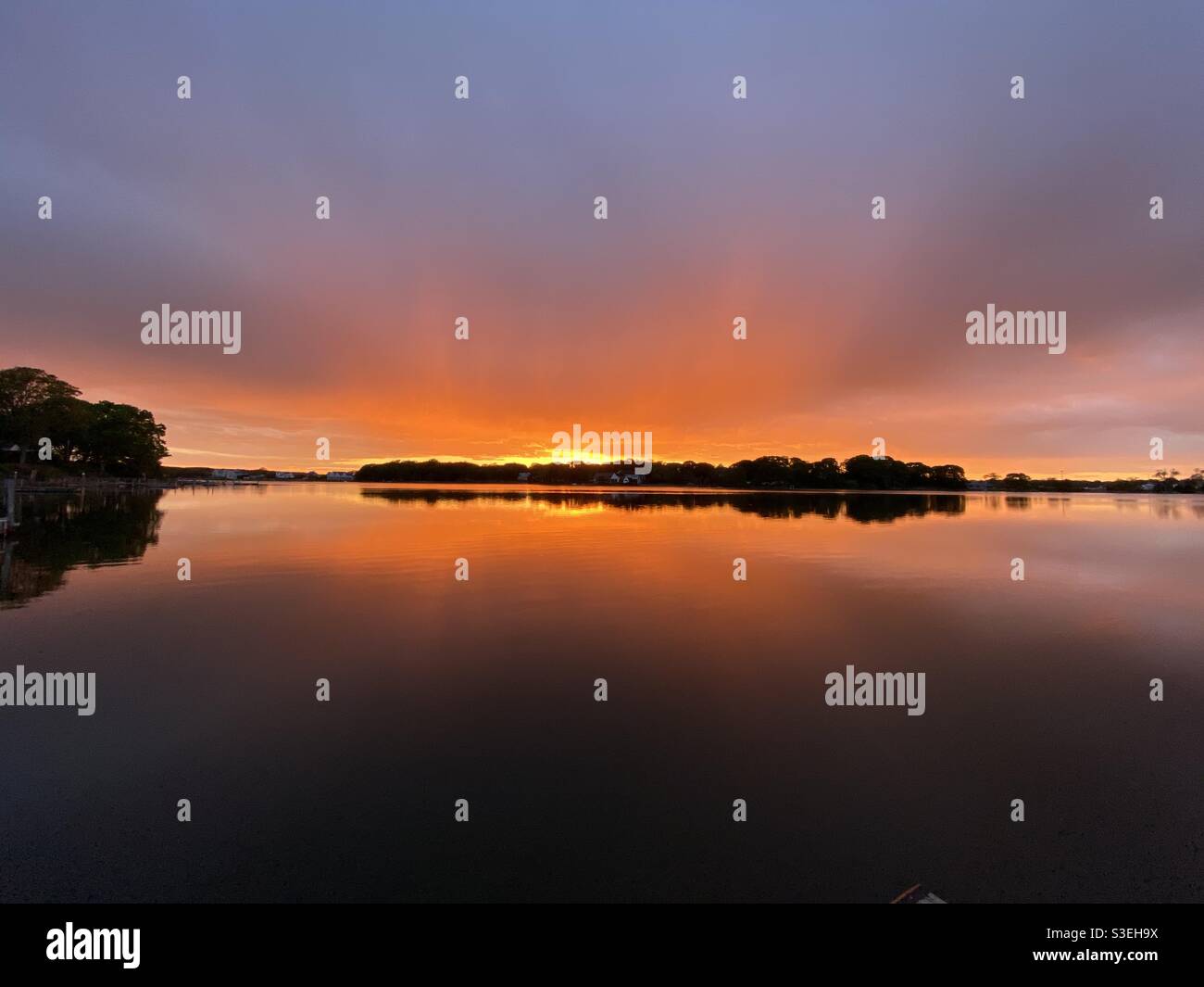 Impresionante puesta de sol naranja en la bahía en los Hamptons Foto de stock
