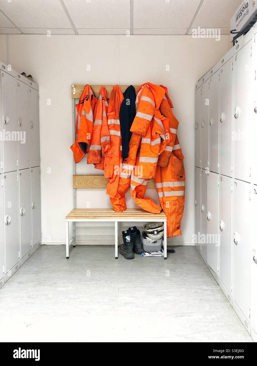 Un vestuario en la construcción o la industria ferroviaria con EPI de alta  visibilidad o ropa de trabajo colgada en ganchos Fotografía de stock - Alamy