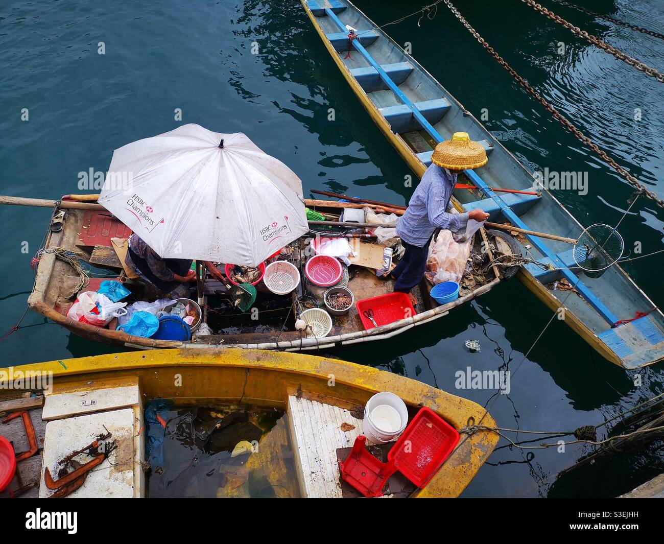 Un pescador chino que vende pescado y marisco de su barco en el puerto de Aberdeen, cerca de AP Lei Chau, en Hong Kong. Foto de stock