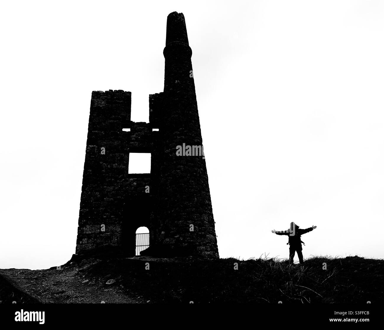 Cornwall en Silhouette - Hombre de pie al lado de una vieja ruina de una mina de Cornualles. Blanco y negro. Foto de stock