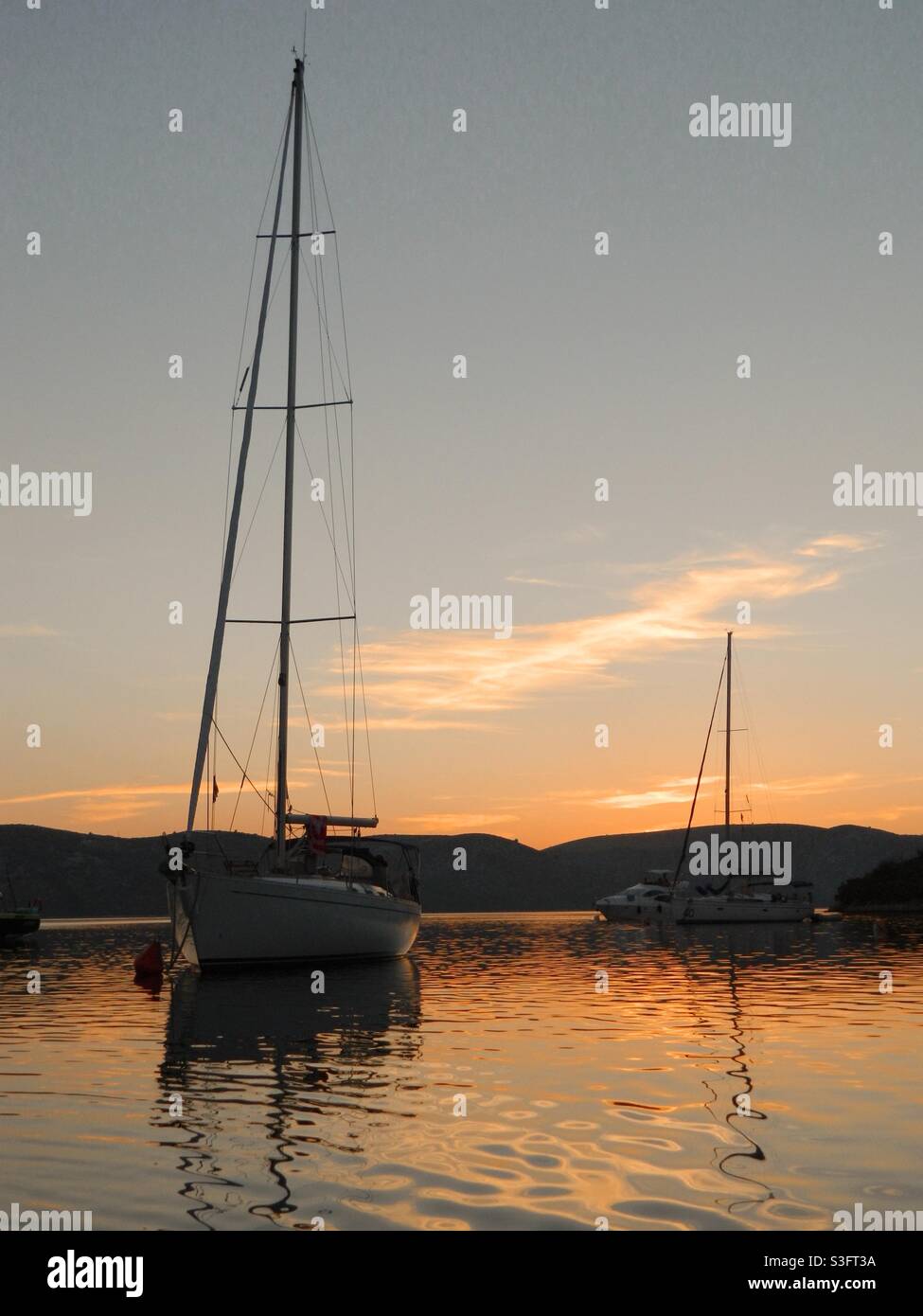 Barcos de vela durante la puesta del sol Foto de stock