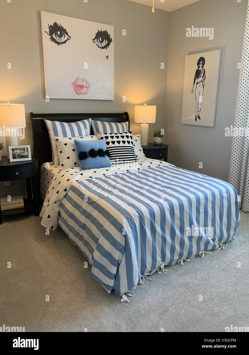 Dormitorio con ropa de cama azul y blanco pintado de paredes grises y  moderno arte en las paredes Fotografía de stock - Alamy