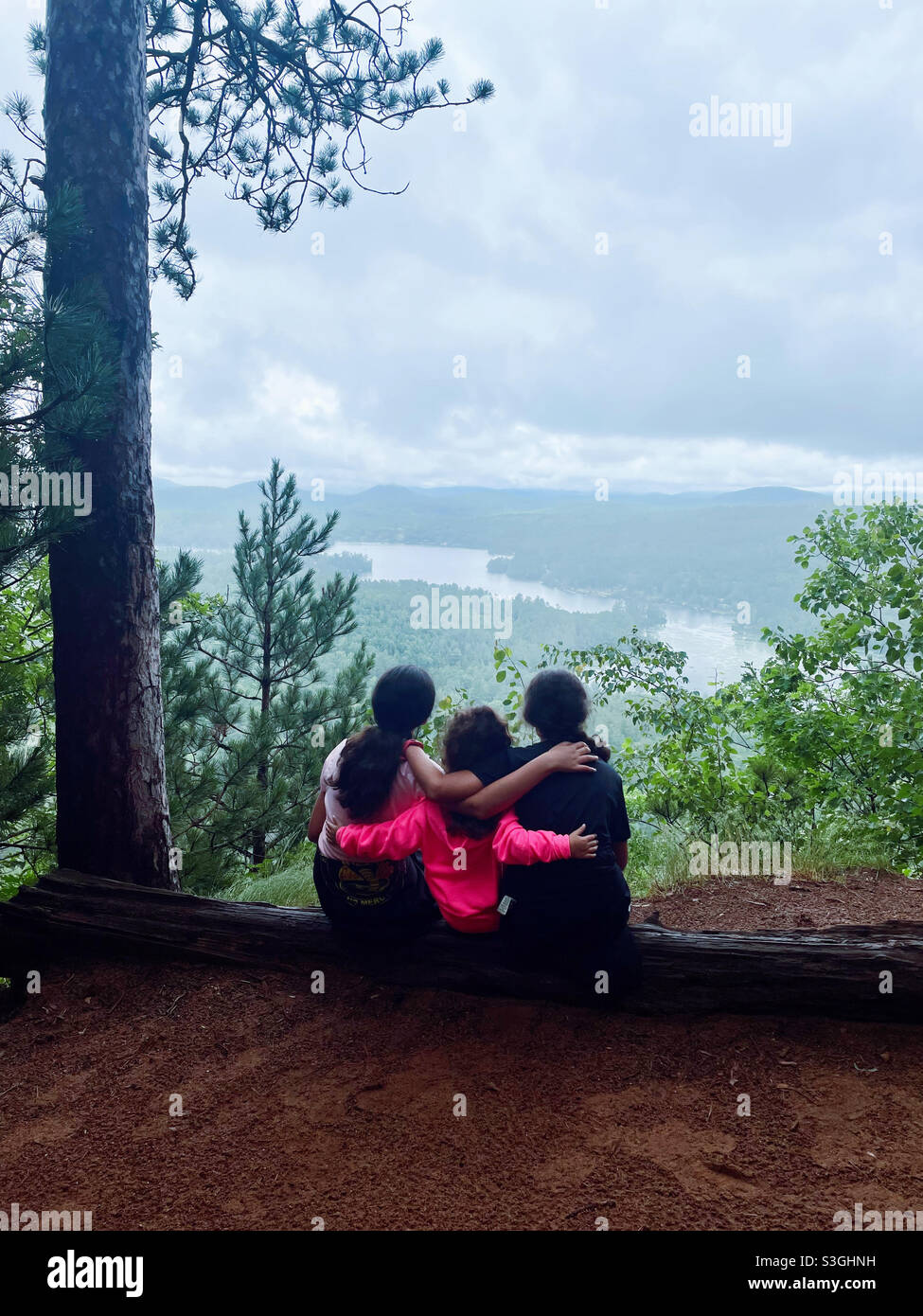 Hermanas mirando los brazos de Mountain View uno alrededor del otro Foto de stock