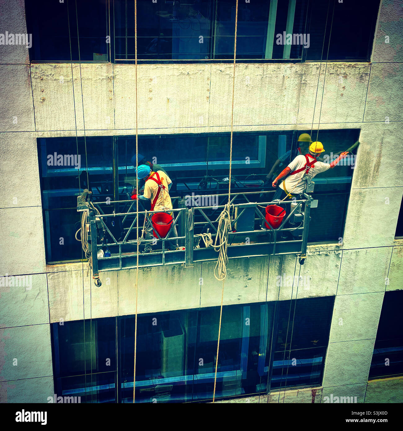dos trabajadores de la ventana limpiando una torre de construcción en un distrito financiero Foto de stock