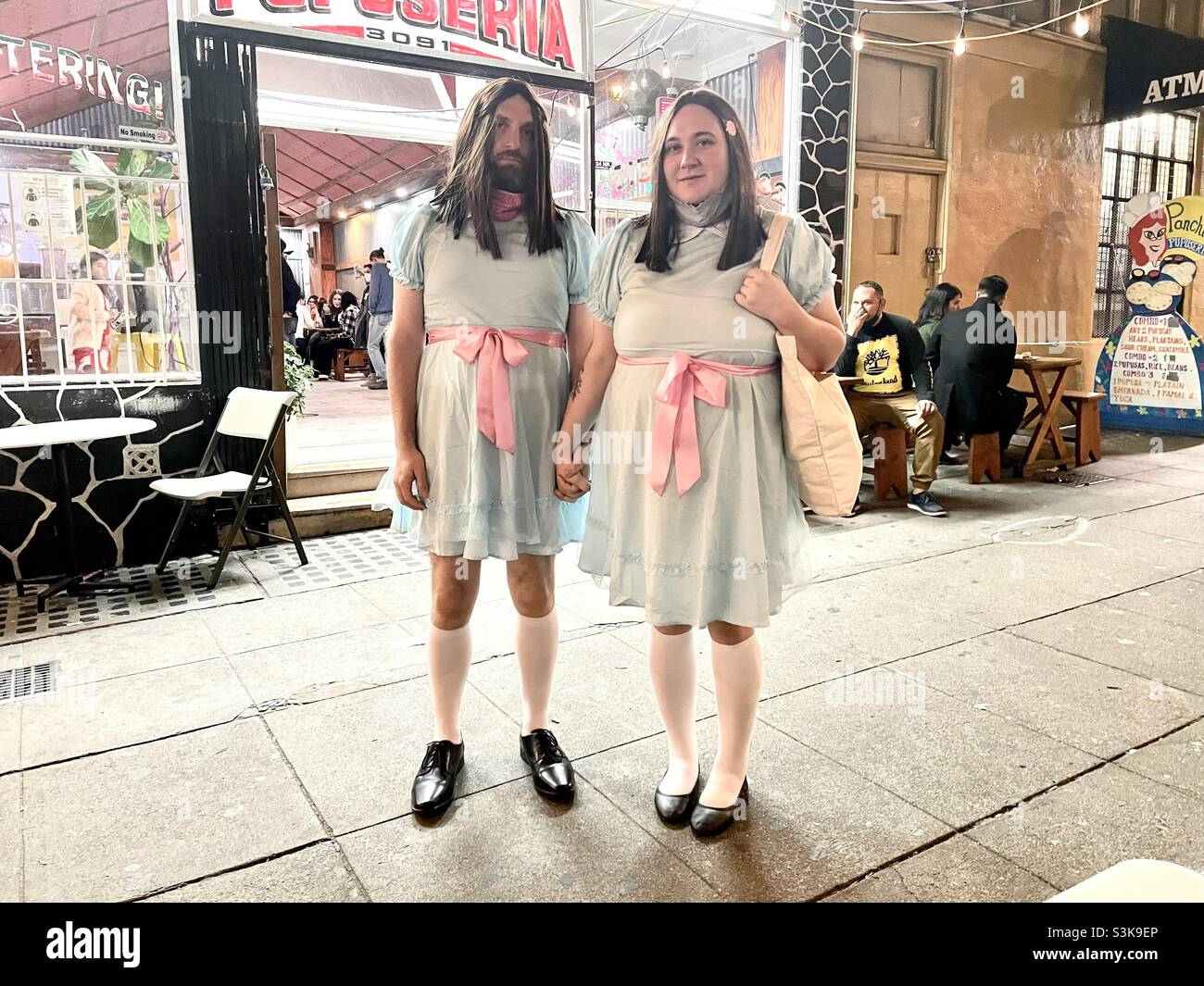 Halloween en el Distrito de la Misión, San Francisco. Una pareja vestida como la pesadilla de los gemelos espeluznantes en el Luminoso. Foto de stock