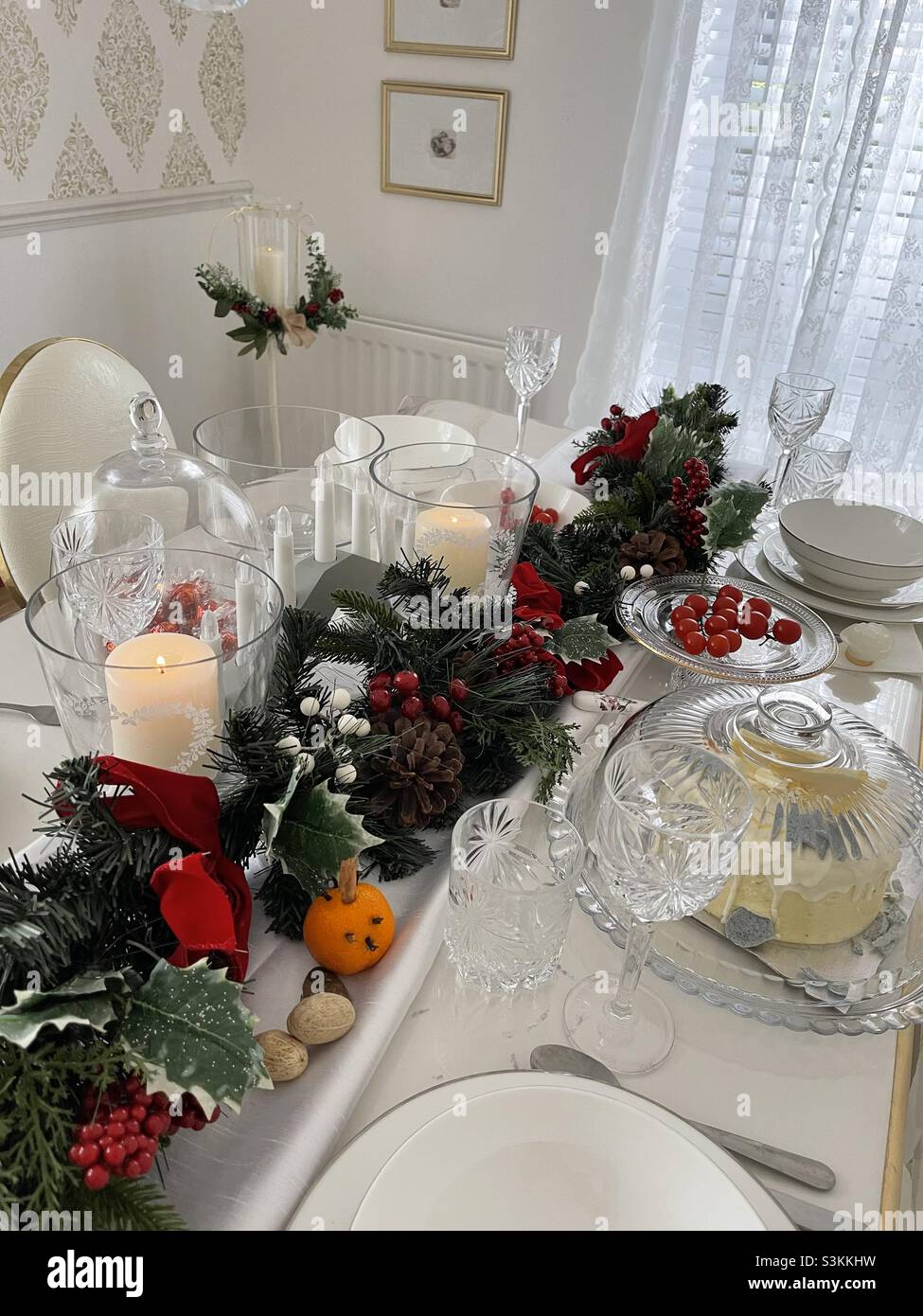 Mesa de Navidad decorada con guirnalda, vela y artículos de cristal  Fotografía de stock - Alamy