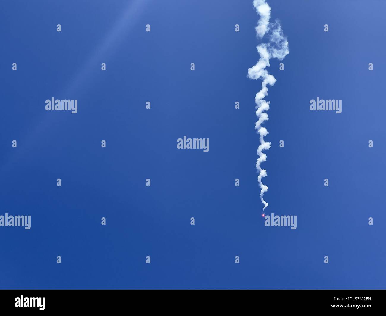 Llamarada de humo contra el cielo azul Foto de stock