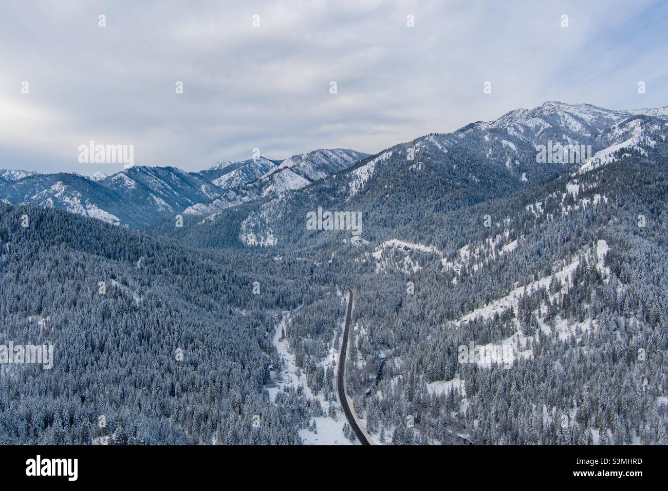 Vista aérea de una autopista en las montañas Cascade cubiertas de nieve Foto de stock