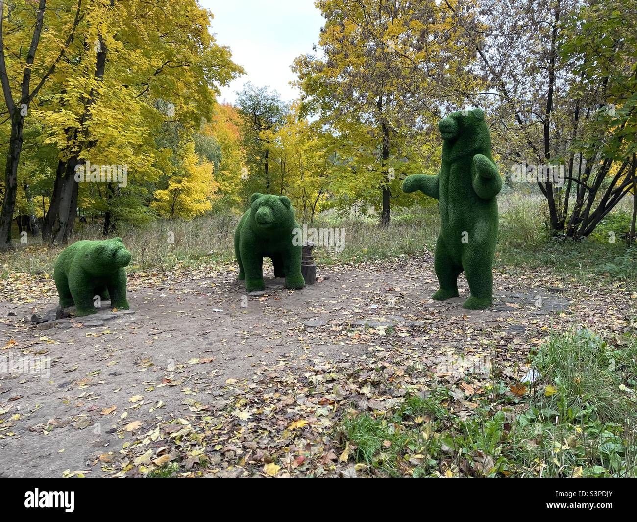 Tres esculturas de osos hechas de hierba falsa Foto de stock