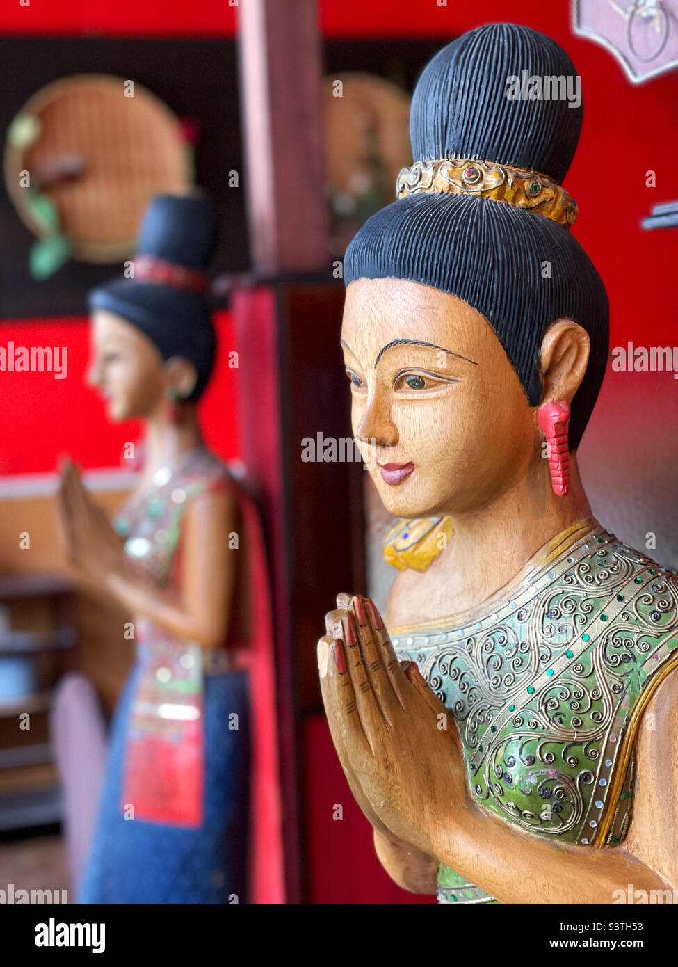 Figuras de madera tallada que dan la bienvenida al restaurante tailandés Foto de stock