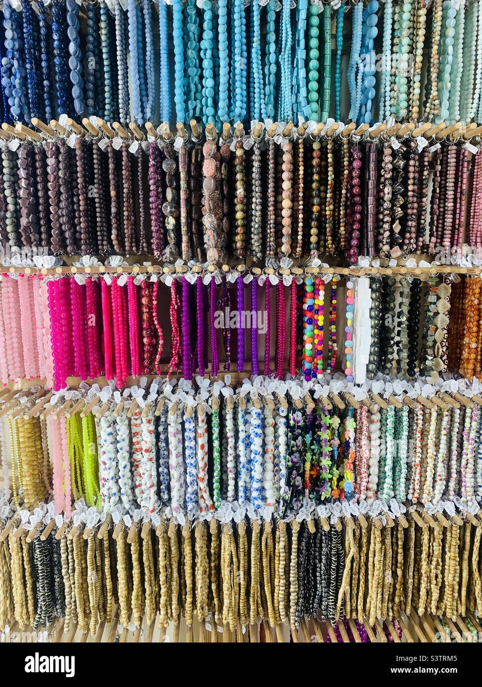 Coloridas pulseras de piedras preciosas expuestas en la tienda Foto de stock