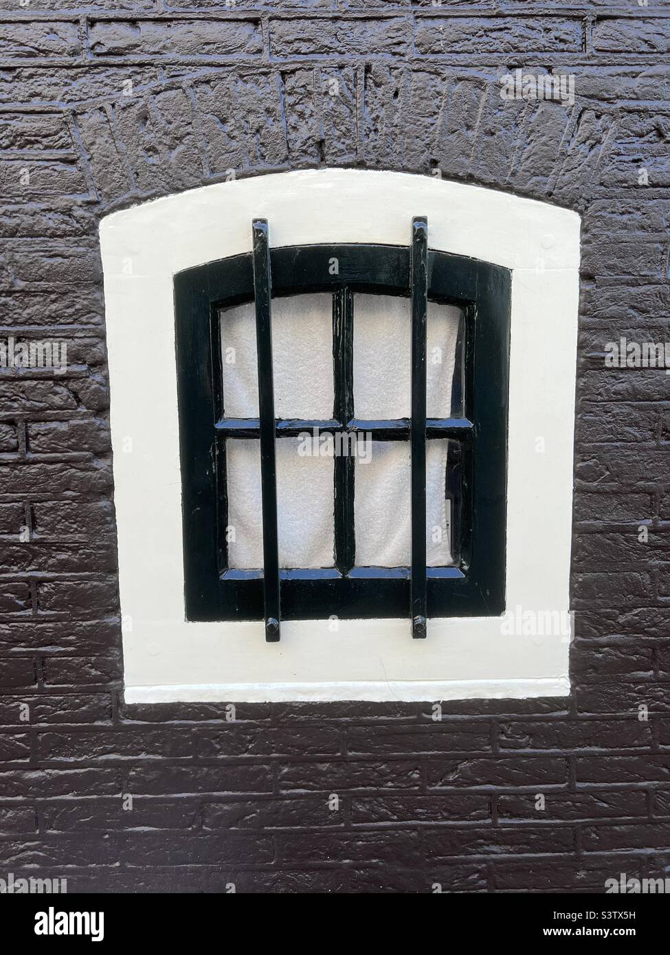 Pequeña ventana con reja de hierro forjado en la zona central de Amsterdam, Holanda Foto de stock