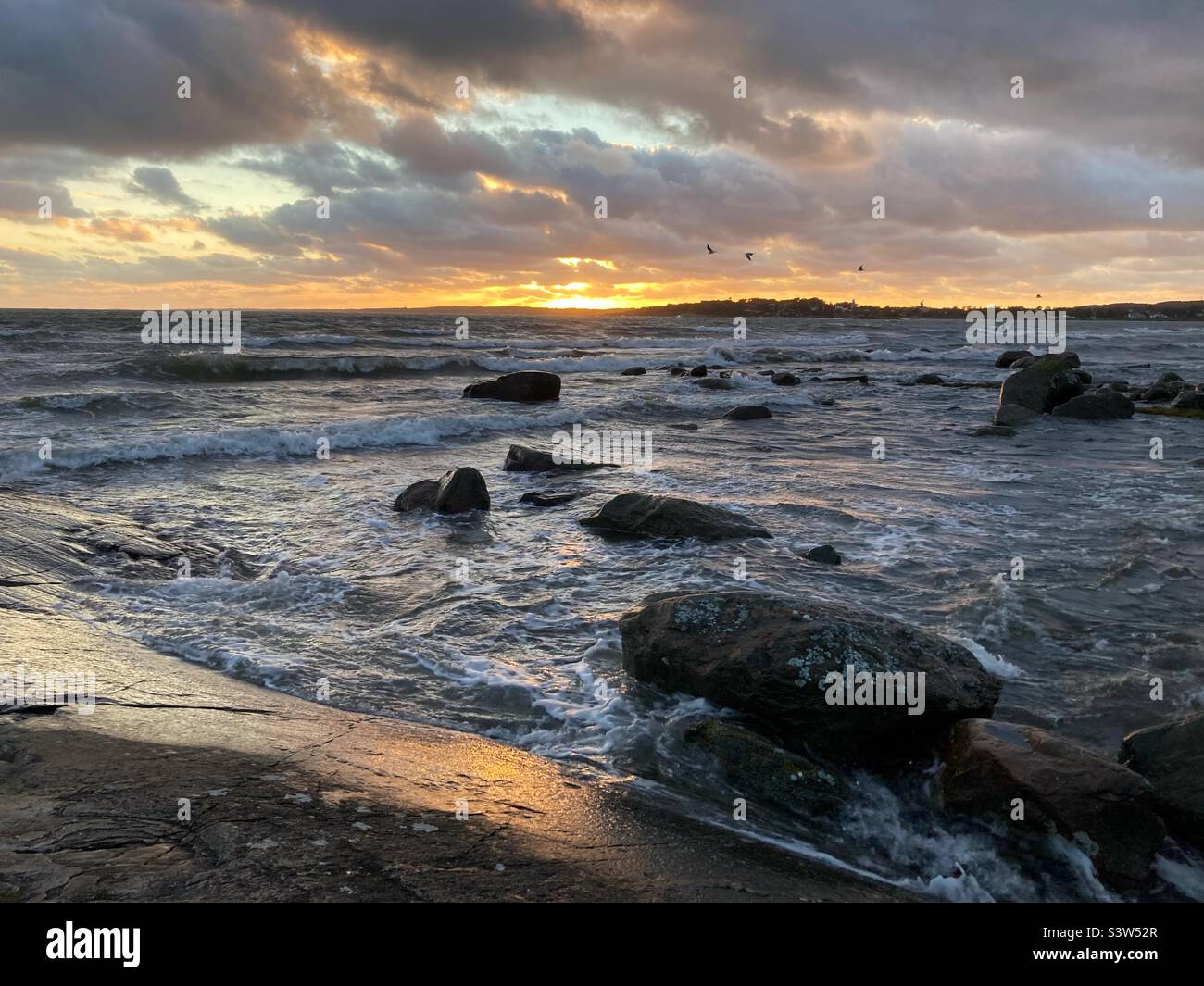 Una puesta de sol en el mar báltico en la costa oeste sueca durante una tormenta de verano Foto de stock