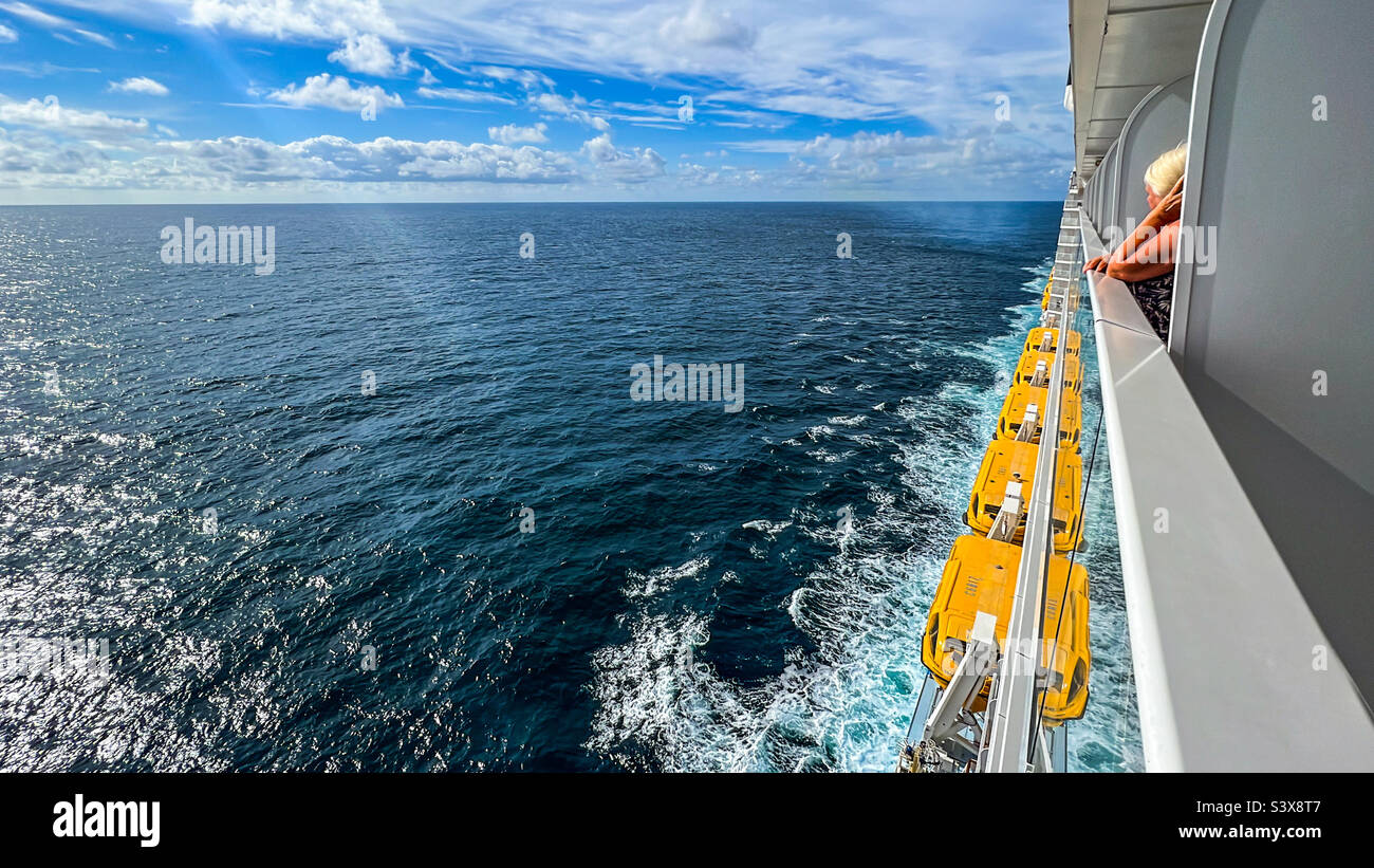 Mujer mirando desde el balcón del crucero mientras estaba en el Océano Atlántico Norte en verano Foto de stock