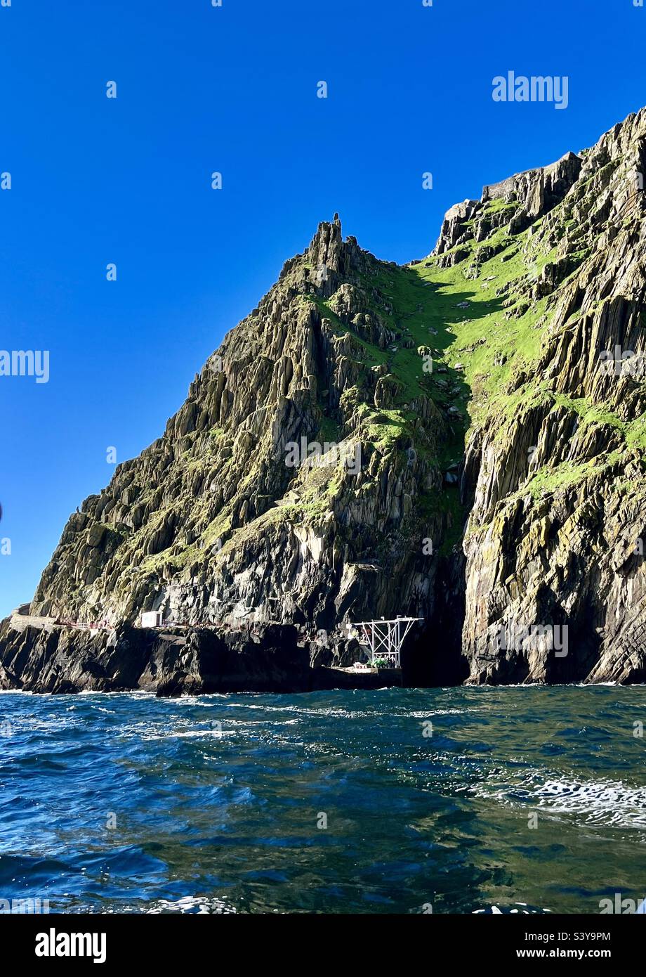 Lugar de aterrizaje de los barcos que le llevan a Skellig Michael - la antigua isla monástica en el condado de Kerry, República de Irlanda - en un día de verano caliente y claro al otro lado del océano Foto de stock