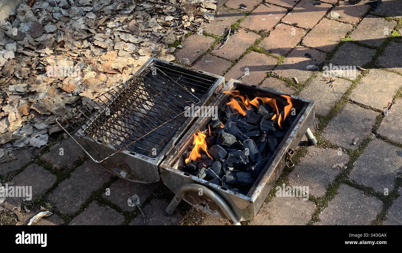 Quemando carbón en una parrilla en el suelo Foto de stock