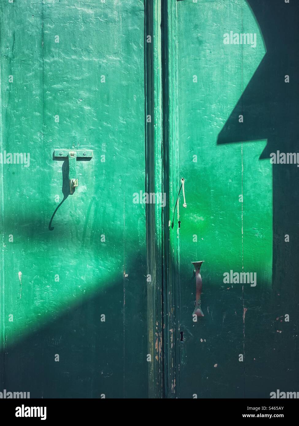 Puerta verde con sombras y luz. Foto de stock