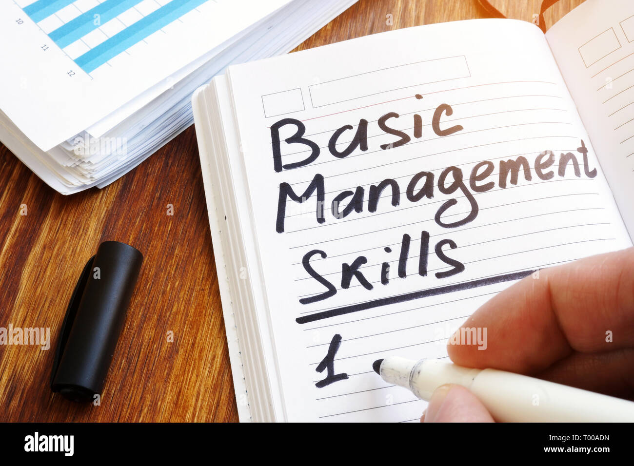 El hombre es escribir la lista de las habilidades básicas de gestión. Foto de stock