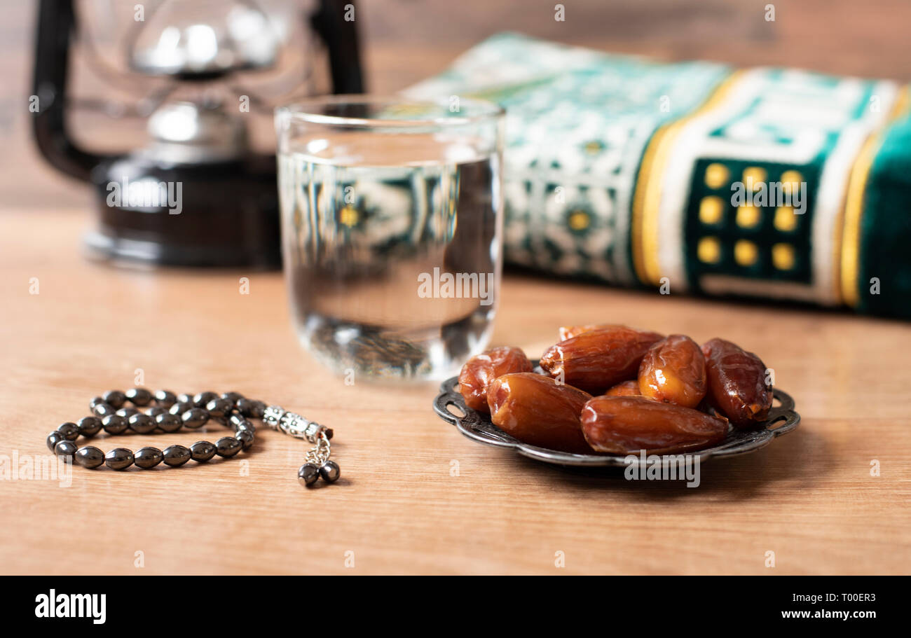 Agua y fechas. Iftar es la comida de la noche. Vista de la decoración Ramadan Kareem fondo de alfombras de vacaciones Foto de stock