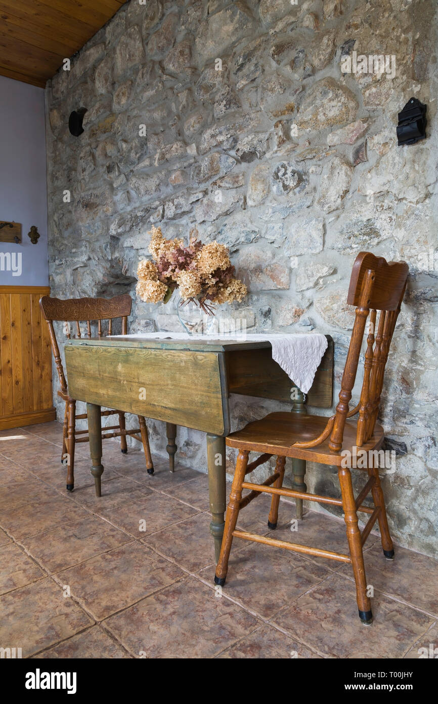 Antigua mesa de comedor y sillas de madera en la pared fieldstone entrada  con suelo de baldosas de cerámica y terracota, dentro de un estilo casa de  campo casa fieldstone1820 Fotografía de
