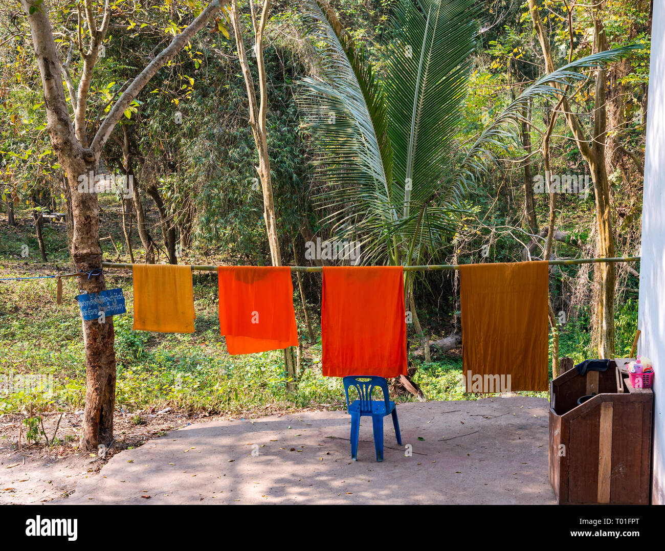 Naranja monje budista batas de secado en el polo de bambú Línea de lavado, Wat Phoy Khuay monasterio, en Luang Prabang, Laos Foto de stock