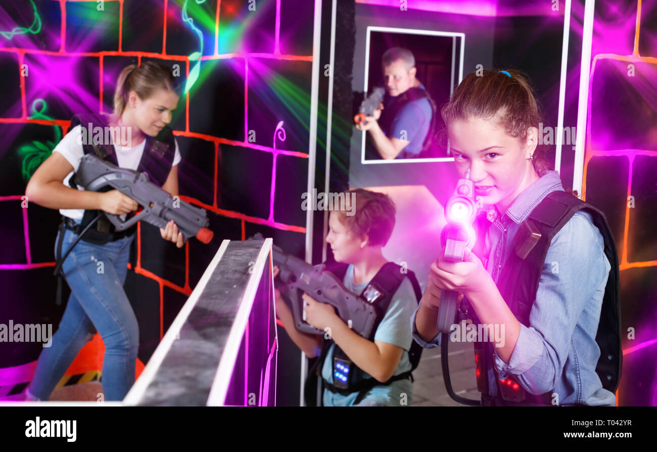 Jovencita emocional con pistola láser jugar laser tag con su familia en el  oscuro laberinto Fotografía de stock - Alamy