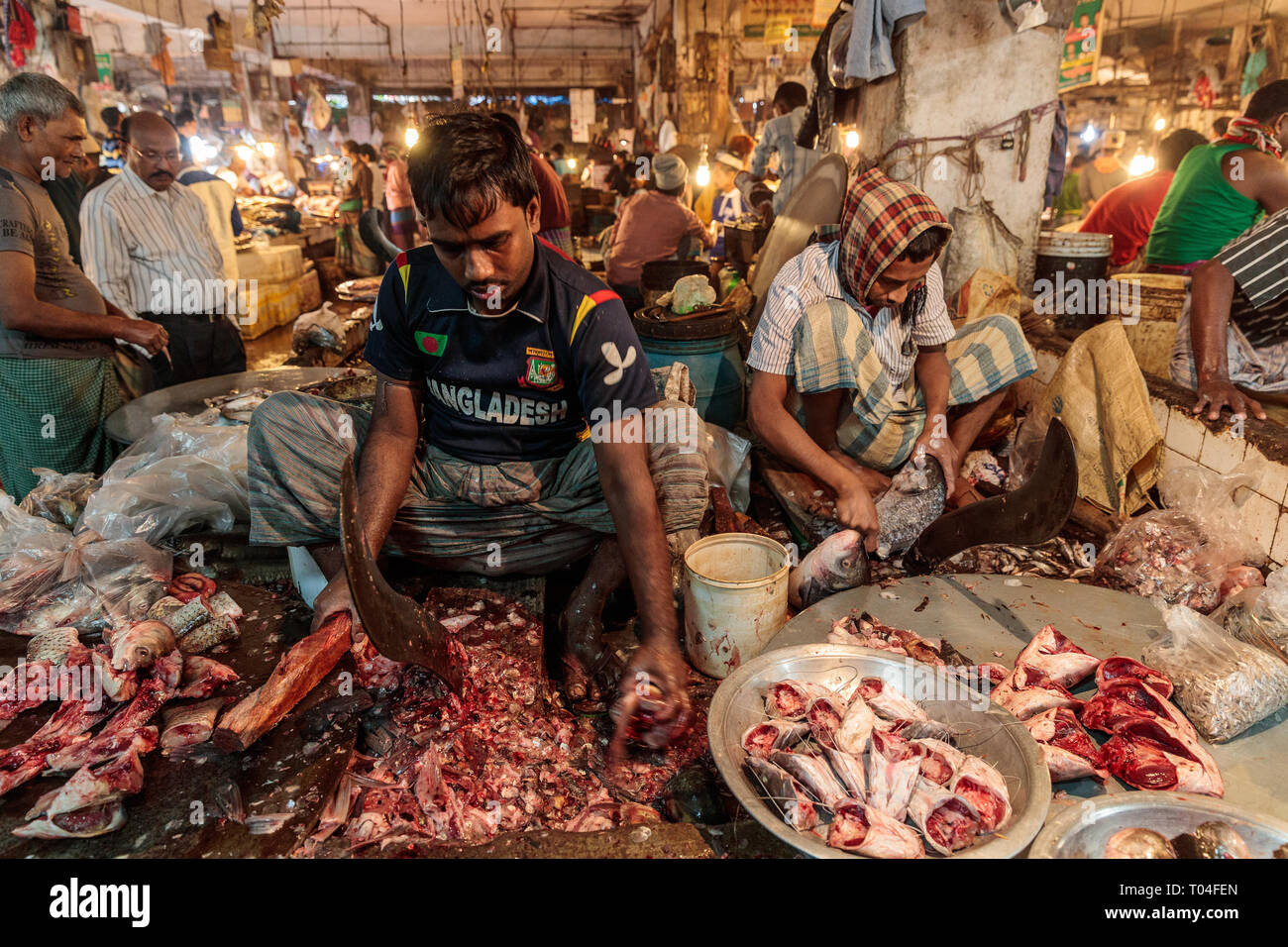 Colorido Mercado de carne con proveedores comerciales y personas que transportan mercancías en las calles de Dhaka, Bangladesh Foto de stock