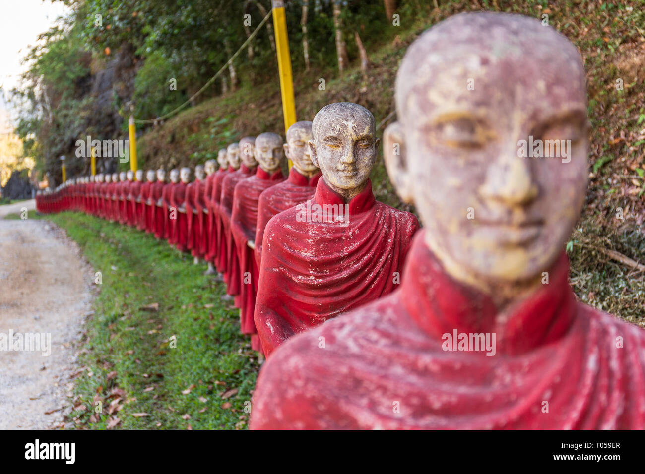 Los monjes budistas estatuas de piedra de fila en el Kaw Ka Thaung cueva, Hpa-an, Myanmar Foto de stock