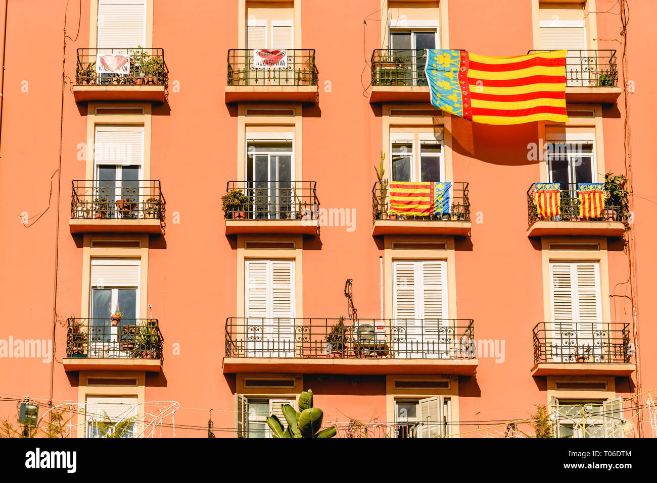 Valencia, España - 16 de marzo de 2019: la fachada de un edificio con un gran señera, la bandera de Valencia, colgando de un balcón, durante la celebración de la fal Foto de stock