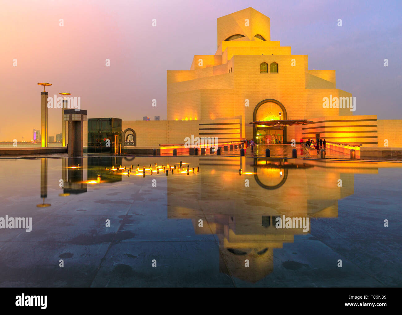 Doha, Qatar - Febrero 16, 2019: el Museo de Arte Islámico, atracción turística popular, a lo largo de la Corniche reflexionando sobre una fuente de agua en el cielo crepuscular Foto de stock