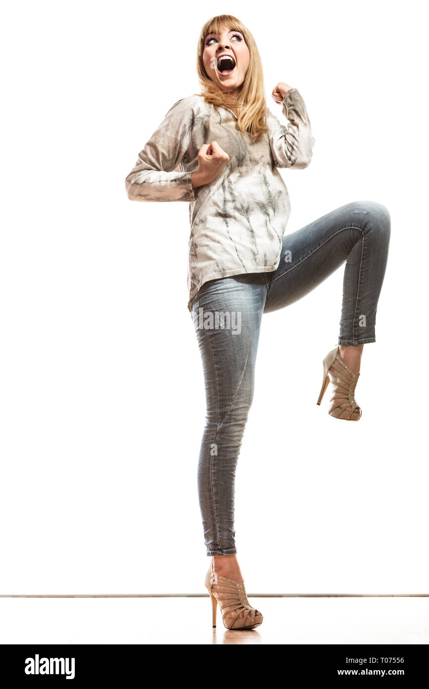 Feliz mujer vistiendo pantalones de mezclilla tacones altos. Chica en  celebrando el éxito de la longitud completa del apretamiento puño aislado  Fotografía de stock - Alamy