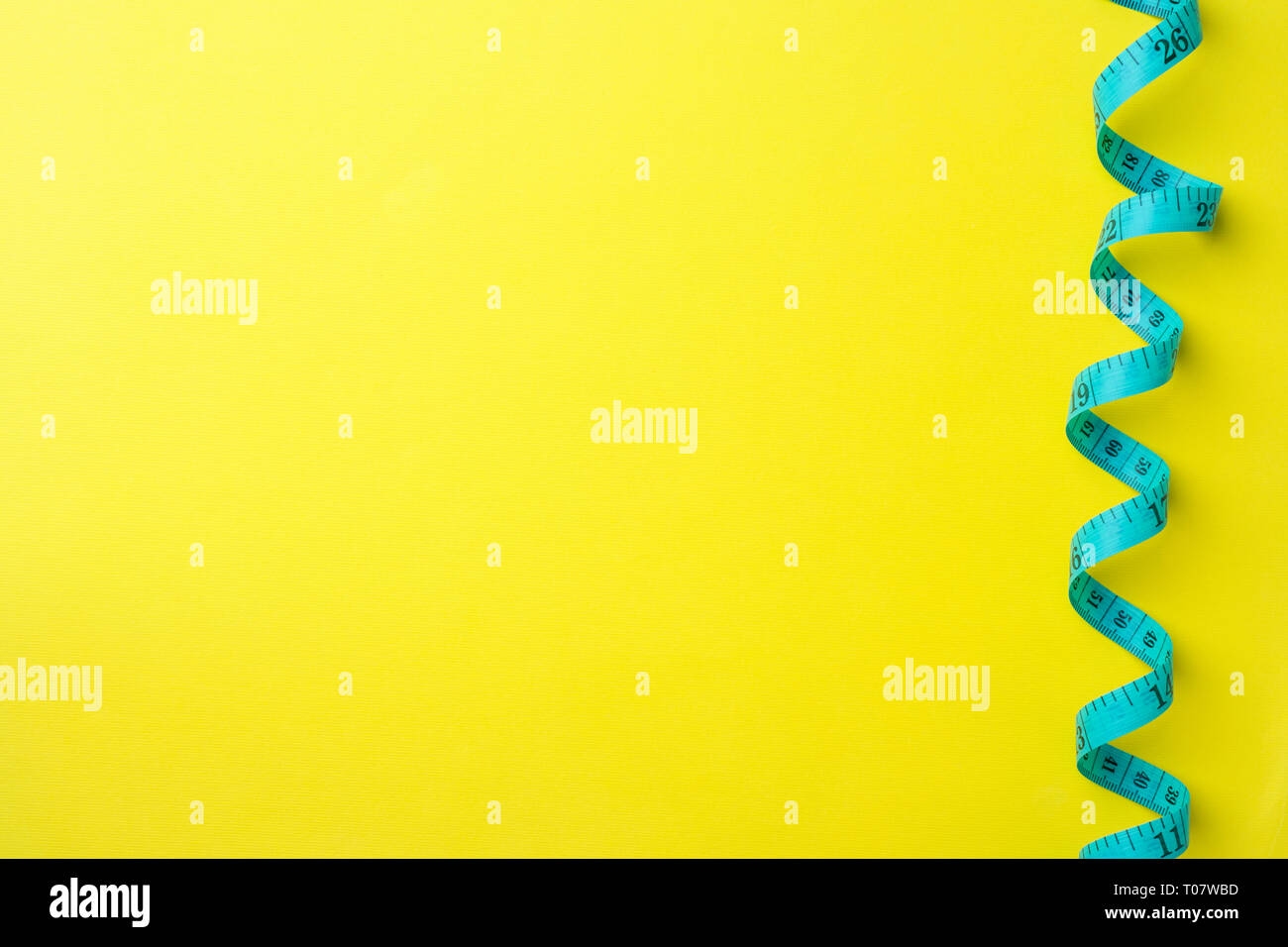 Regla centímetro plegada con compartimientos de medición sobre un fondo amarillo. Artesanía y confección concepto. Espacio de copia Foto de stock