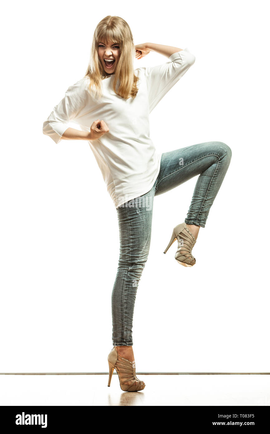 La moda. Joven Mujer pantalones de mezclilla camisa blanca top tacones  altos. Modelo femenino en toda su longitud celebrando el éxito con el brazo  levantado aislado Fotografía de stock - Alamy