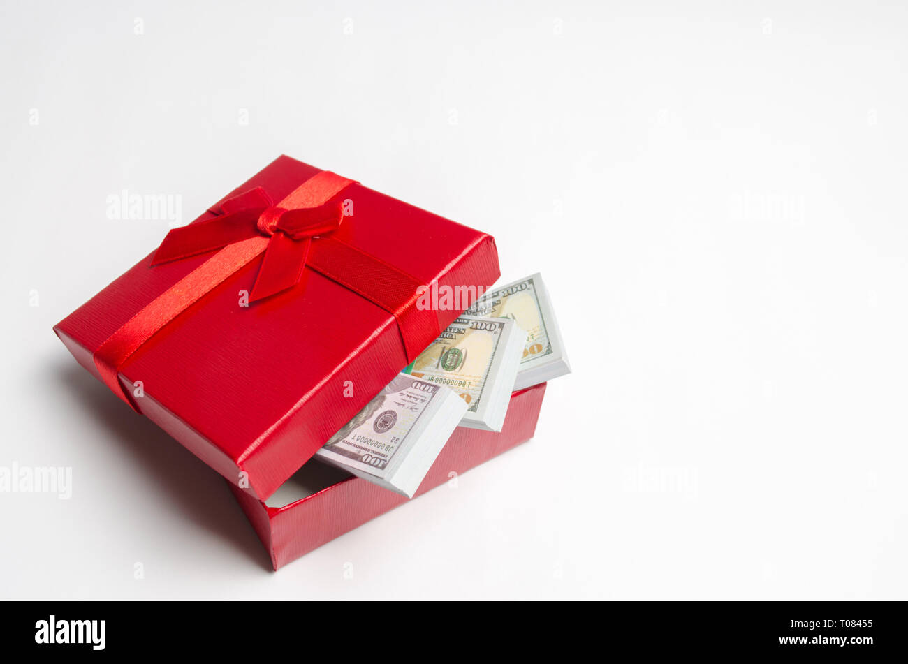 Dólares en una caja de regalo roja sobre un fondo blanco. Buscar un regalo  para las vacaciones. Certificado de Regalo. El mejor regalo es el dinero.  Costo de los regalos. Valente Fotografía