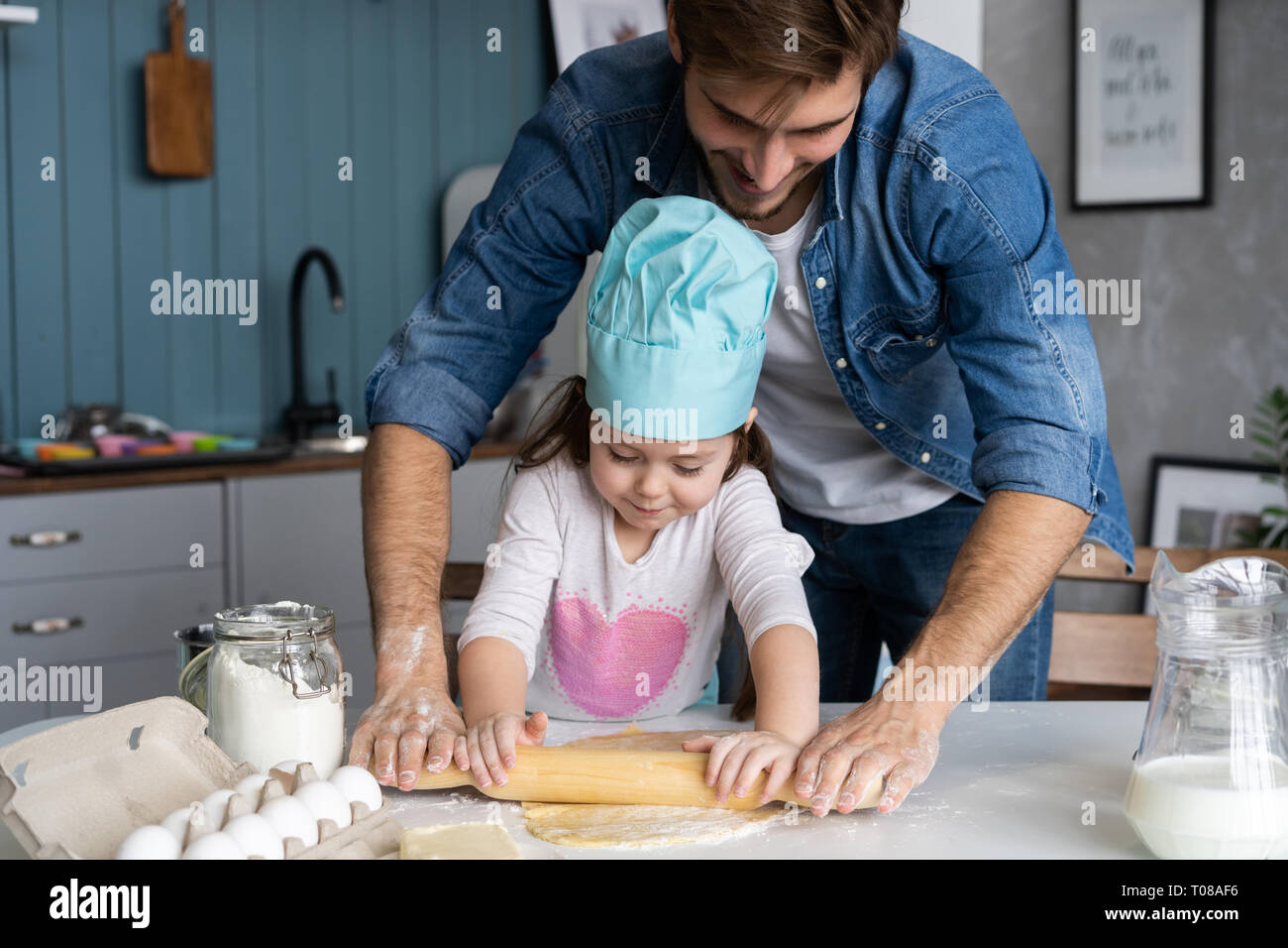 Papá con hija pastel hornear juntos en la cocina de hogar. Foto de stock