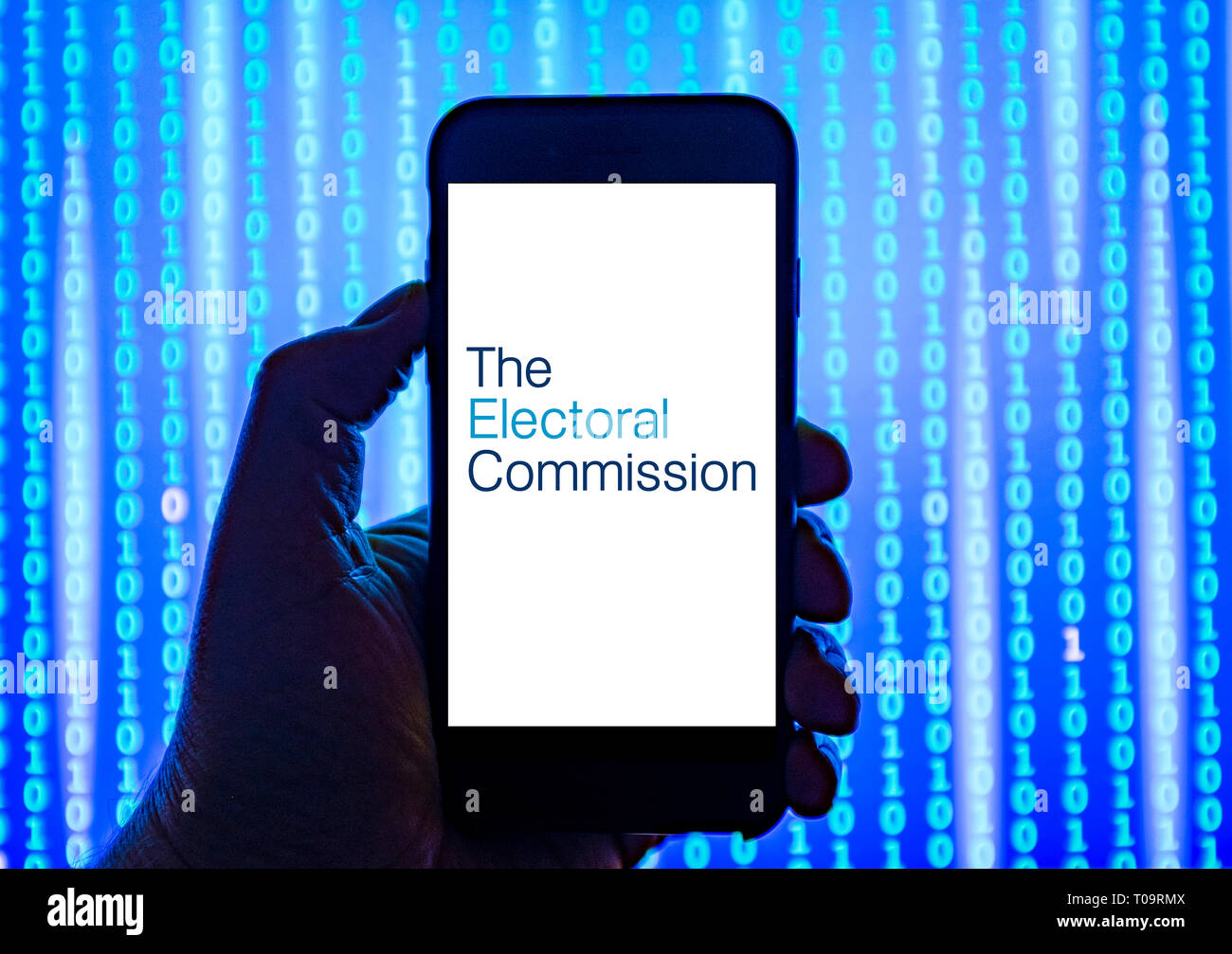 Persona sosteniendo el teléfono inteligente con la Comisión Electoral con el logotipo que aparece en la pantalla. Foto de stock