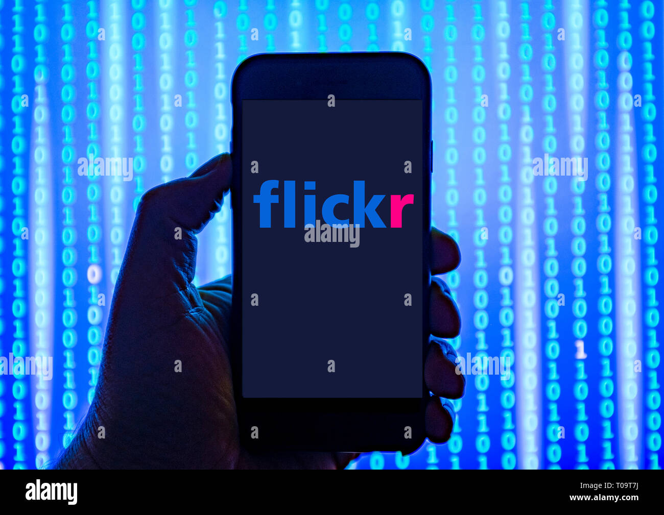 Persona sosteniendo el teléfono inteligente con Flickr Logotipo mostrado en la pantalla. Foto de stock
