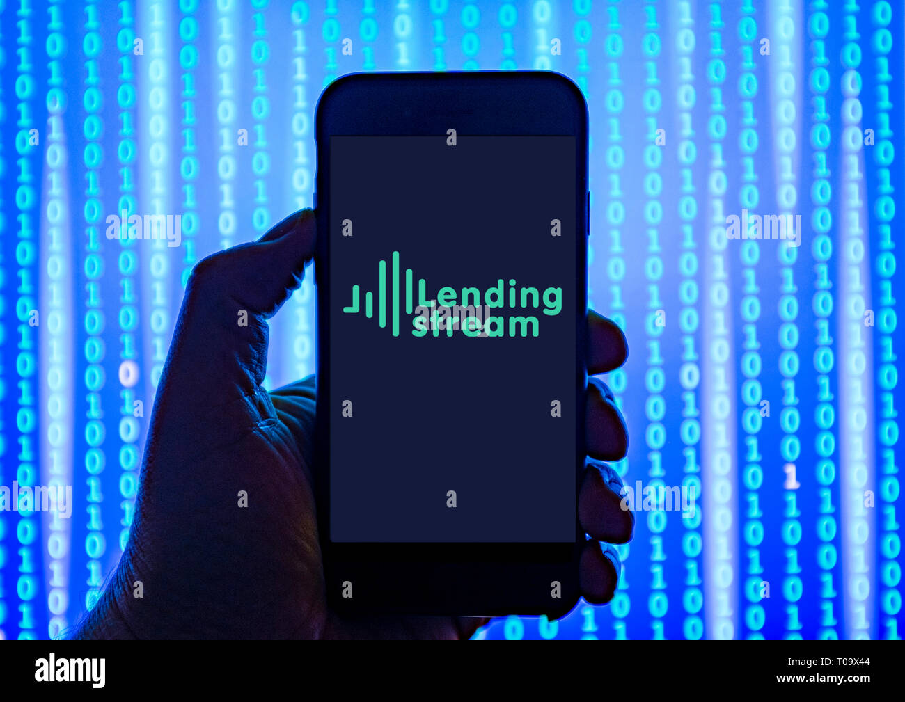 Persona sosteniendo el teléfono inteligente con préstamos de financiación multitud Stream Logotipo mostrado en la pantalla. Foto de stock