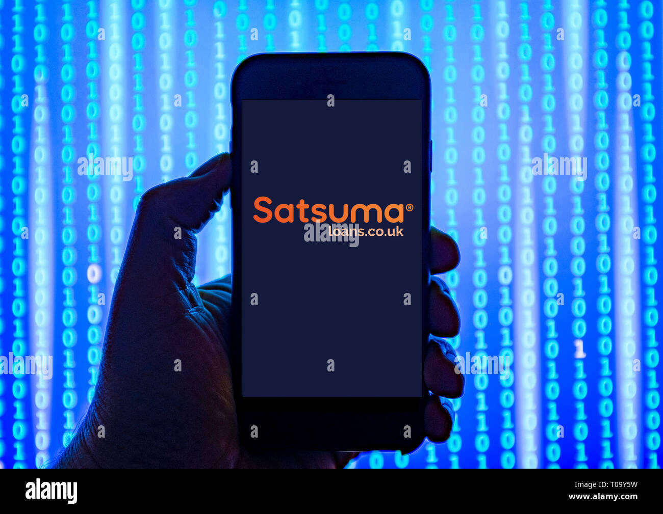 Persona sosteniendo el teléfono inteligente con Satsuma préstamos en línea- prestamista logotipo mostrado en la pantalla. Foto de stock