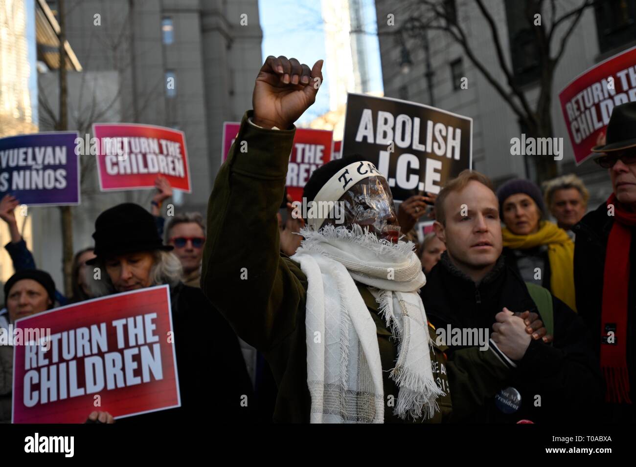 Nueva York, NY, EUA. El 19 de marzo de 2019. Los partidarios de la Estatua de la libertad de escolta Patricia Okoumou escalador, con plástico transparente que cubre su rostro, en la corte federal antes de su condena por ella, el 4 de julio de 2018, un acto de desobediencia civil para protestar contra las políticas de inmigración de la administración Trump. Okoumou fue condenado en diciembre de cargos menores de allanamiento de morada, conducta desordenada, e interfieren con el funcionamiento del gobierno. Crédito: Joseph Reid/Alamy Live News Foto de stock
