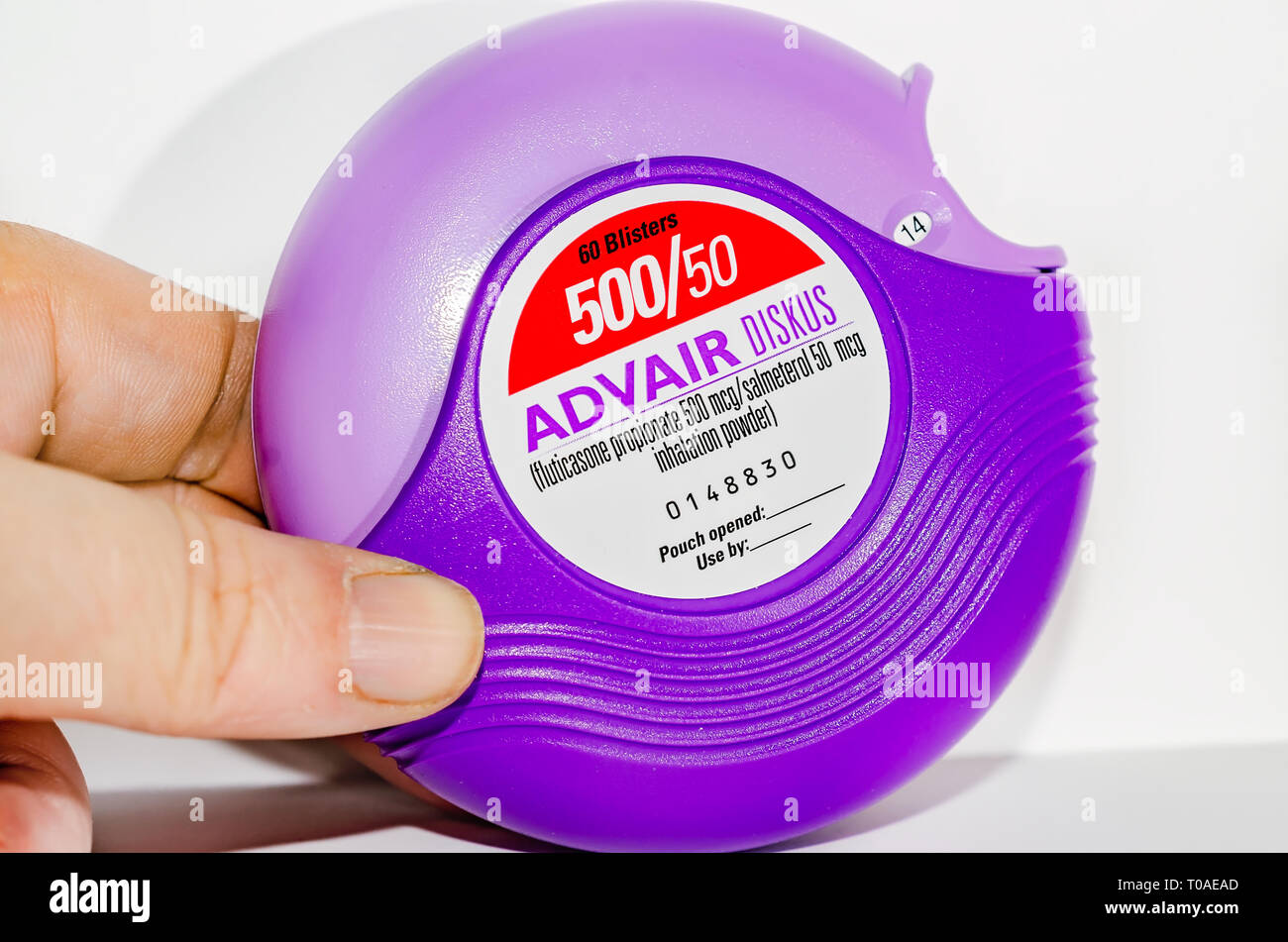 El Advair Diskus inhalador, realizados por GlaxoSmithKline​, es retratada en blanco. Los ingredientes activos en Advair son propionato de fluticasona y salmeterol. Foto de stock