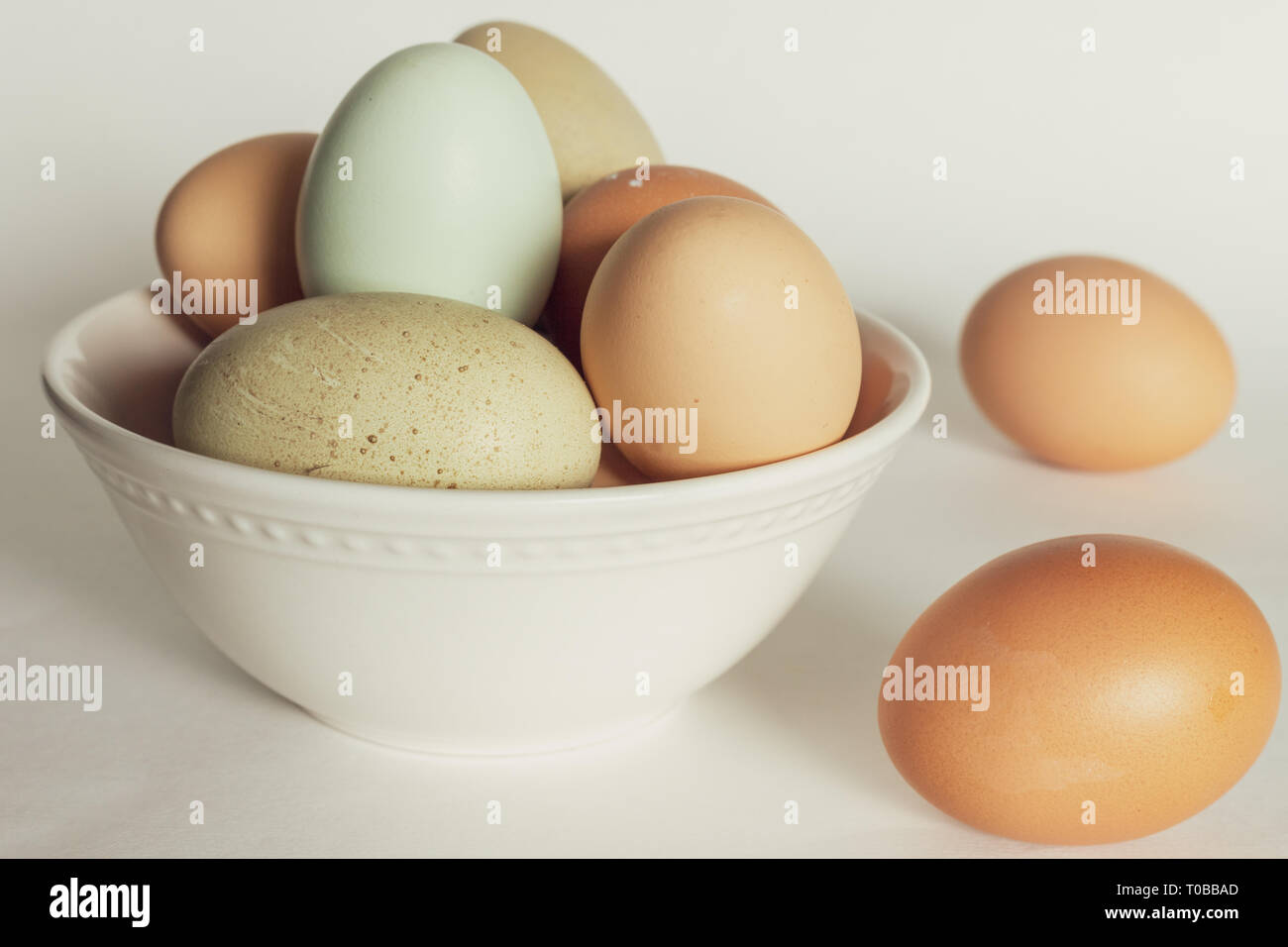 Coloridos huevos de pollo fresco en un tazón Foto de stock