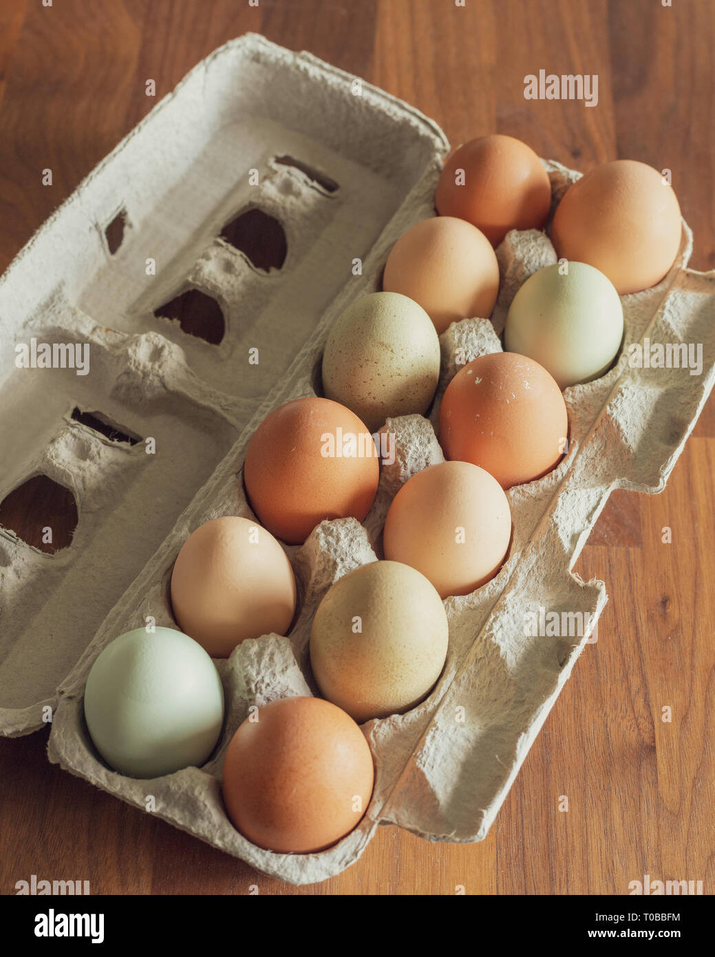 Coloridos huevos de pollo fresco en cartón Foto de stock