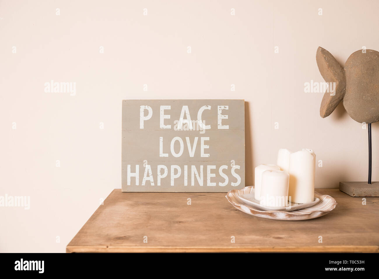 Habitación de estilo escandinavo hipster interior. Junta de humor. Antigua junta rayado ,cita la paz, el amor, la felicidad. Velas blancas,pot con suculentas.rústico Foto de stock